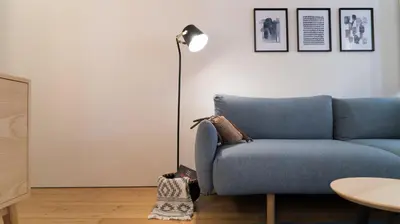a living room with a blue couch and a lamp at Souto Apartments in Porto