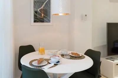 a white table with a plate of food on it at Heart of D. Pedro Apartments III in Porto