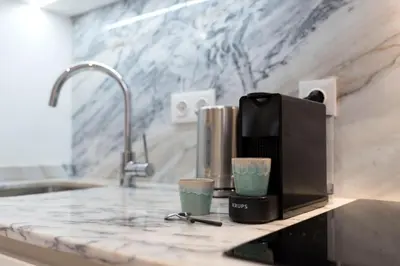 a kitchen counter with a coffee maker and two cups at Heart of D. Pedro Apartments III in Porto