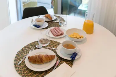 a table topped with plates of breakfast foods and drinks at Heart of D. Pedro Apartments III in Porto