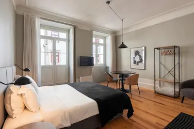 a bedroom with a bed and a table and chairs at Cedofeita Premium Apartment 1F in Porto