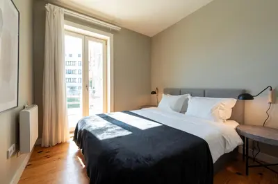 a bedroom with a large bed and a window at Cedofeita Premium Apartment 1B in Porto