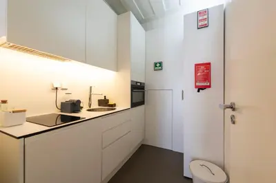 a bathroom with white cabinets and a sink and a toilet at Cedofeita Premium Apartment 1B in Porto