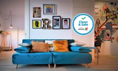 a blue couch in a room with a sign at Art District - POP & ROCK Apartments in Porto