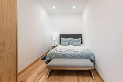 a bedroom with a bed with blue pillows at LovelyStay - 1BR Flat w AC and Balcony by Aliados in Porto