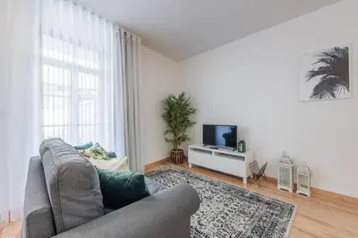 a living room with a couch and a tv at LovelyStay - 1BR Flat w AC and Balcony by Aliados in Porto