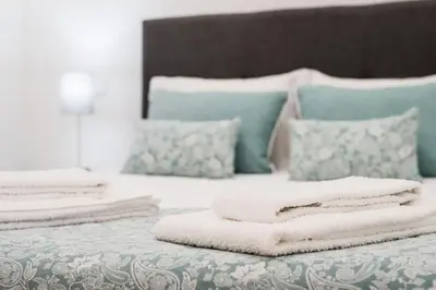 a pile of towels sitting on top of a bed at LovelyStay - 1BR Flat w AC and Balcony by Aliados in Porto
