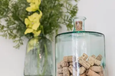 a glass bottle filled with wine corks next to a vase at LovelyStay - 1BR Flat w AC and Balcony by Aliados in Porto