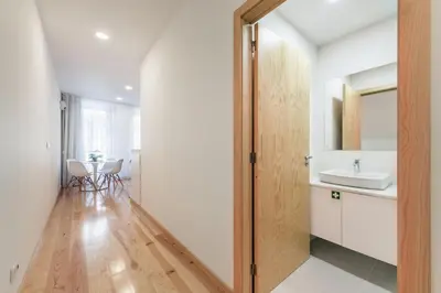a bathroom with a sink and a mirror at LovelyStay - 1BR Flat w AC and Balcony by Aliados in Porto