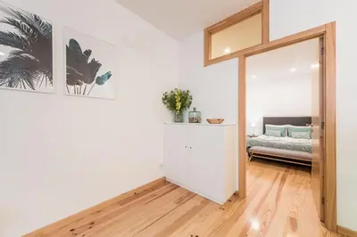 a living room with a bed and a sliding glass door at LovelyStay - 1BR Flat w AC and Balcony by Aliados in Porto