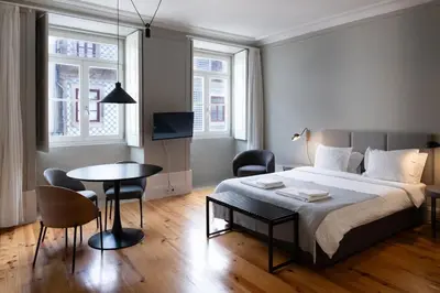 a bedroom with a bed and a table and chairs at Cedofeita Premium Apartment 2F in Porto