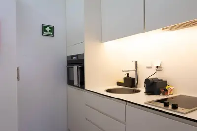a white kitchen with a sink and a microwave at Cedofeita Premium Apartment 2F in Porto