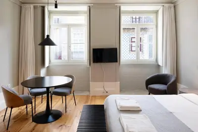 a bedroom with a bed and a table and chairs at Cedofeita Premium Apartment 2F in Porto
