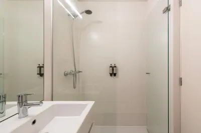 a white bathroom with a sink and a shower at Cedofeita Premium Apartment 2B in Porto