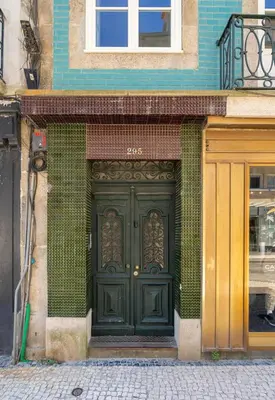 a green door on the side of a building at Cedofeita Premium Apartment 2B in Porto