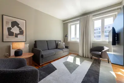 a living room with a couch and a chair at Cedofeita Premium Apartment 2B in Porto
