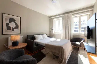 a bedroom with a bed and two chairs at Cedofeita Premium Apartment 2B in Porto
