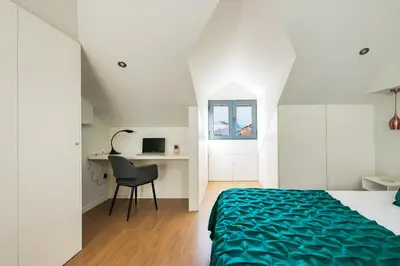 a bedroom with a bed and a desk with a chair at Kings Oporto Apartments in Porto