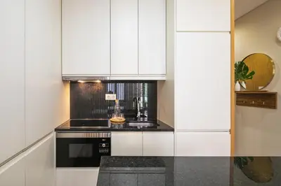 a kitchen with white cabinets and a black stove at Kings Oporto Apartments in Porto