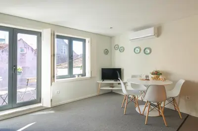 a living room with a table and chairs and a television at Kings Oporto Apartments in Porto