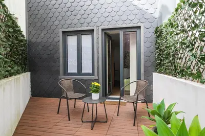 a patio with chairs and a table and a window at Kings Oporto Apartments in Porto