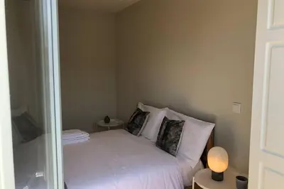 a small bedroom with a bed with white sheets and pillows at CL Freixo Apartment in Porto