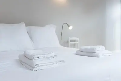 a white bed with towels on top of it at LovelyStay - Porto Windows with AC by central station in Porto