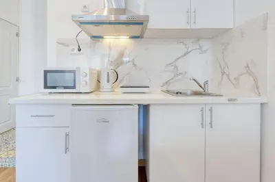 a white kitchen with a sink and a microwave at Travel & live Santa Catarina apartment in Porto