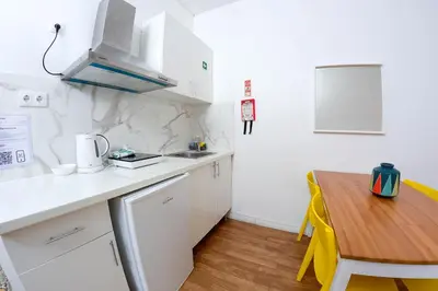 a small kitchen with a wooden table and a counter top at Travel & live Santa Catarina apartment in Porto