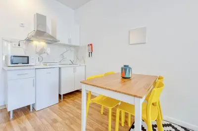 a kitchen with a wooden table and yellow chairs at Travel & live Santa Catarina apartment in Porto