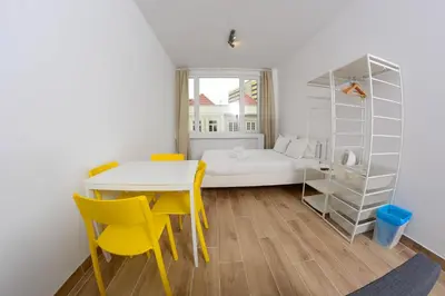 a small room with a bed and a table and chairs at Travel & live Santa Catarina apartment in Porto