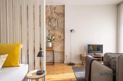 a living room with a couch and a tv at Light-filled Bonjardim Apartments in Porto