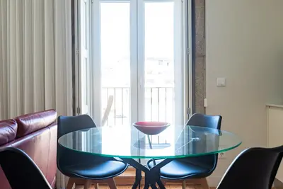 a glass table and chairs in a living room at Light-filled Bonjardim Apartments in Porto