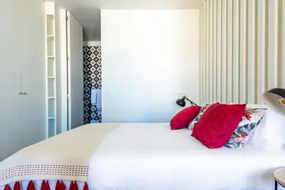 a bedroom with a large white bed with red pillows at Light-filled Bonjardim Apartments in Porto