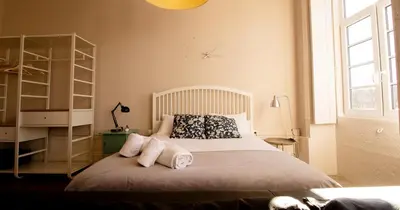 a bedroom with a bed with two pillows on it at Casa do Recanto in Porto