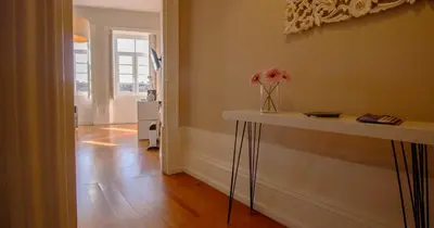 a room with a table with a vase of flowers on it at Casa do Recanto in Porto