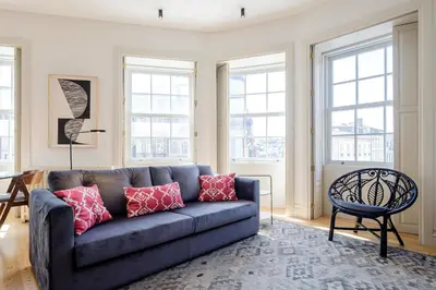 a living room with a blue couch and windows at BOUTIQUE Rentals- THE RIBEIRA***** Apt great views in Porto