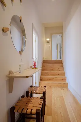 a hallway with wooden stairs with a mirror and benches at BOUTIQUE Rentals- THE RIBEIRA***** Apt great views in Porto