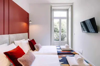 a bedroom with two beds and a television on a wall at Bruno's Wine House in Vila Nova de Gaia