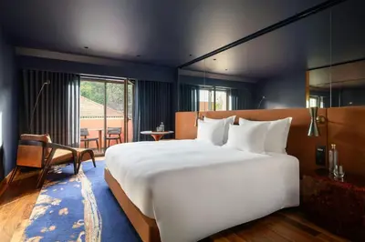 a bedroom with a large white bed and a table at Forte de Gaia, Autograph Collection in Vila Nova de Gaia