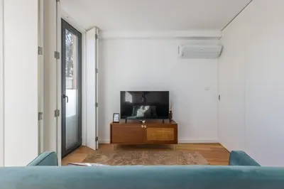 a living room with a tv on a wooden table at Terrace Bliss with AC Downtown Porto in Porto