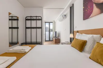 a bedroom with a large white bed and windows at Terrace Bliss with AC Downtown Porto in Porto