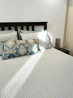 a white bed with a blue pillow on it at Porto Historic - Apartment with Private Patio in Porto
