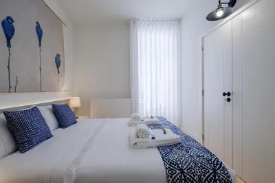 a bedroom with a large white bed with blue pillows at BOUTIQUE Rentals-Flores Terrace historical centre in Porto
