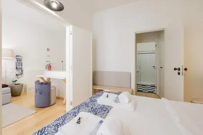a white room with a bed and a mirror at BOUTIQUE Rentals-Flores Terrace historical centre in Porto