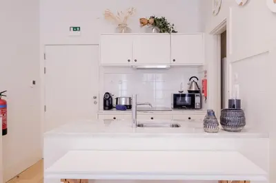 a kitchen with white cabinets and a sink at BOUTIQUE Rentals-Flores Terrace historical centre in Porto
