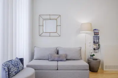 a living room with a couch and a mirror at BOUTIQUE Rentals-Flores Terrace historical centre in Porto