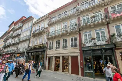 a group of people walking down a street with buildings at BOUTIQUE Rentals-Flores Terrace historical centre in Porto