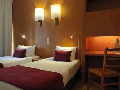 a hotel room with two beds and a desk at Vilar Oporto Hotel in Porto