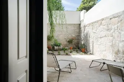 a patio with a table and chairs next to a stone wall at Amy Porto in Porto